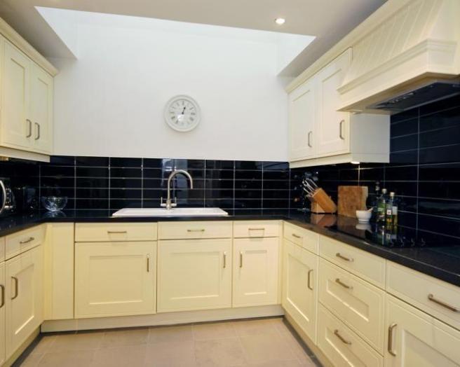 cream kitchen with black wall tiles