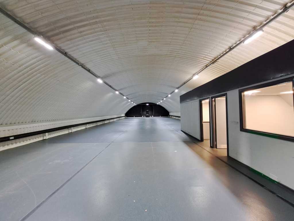 An empty arch with white lining and a WC cubicle to the front.