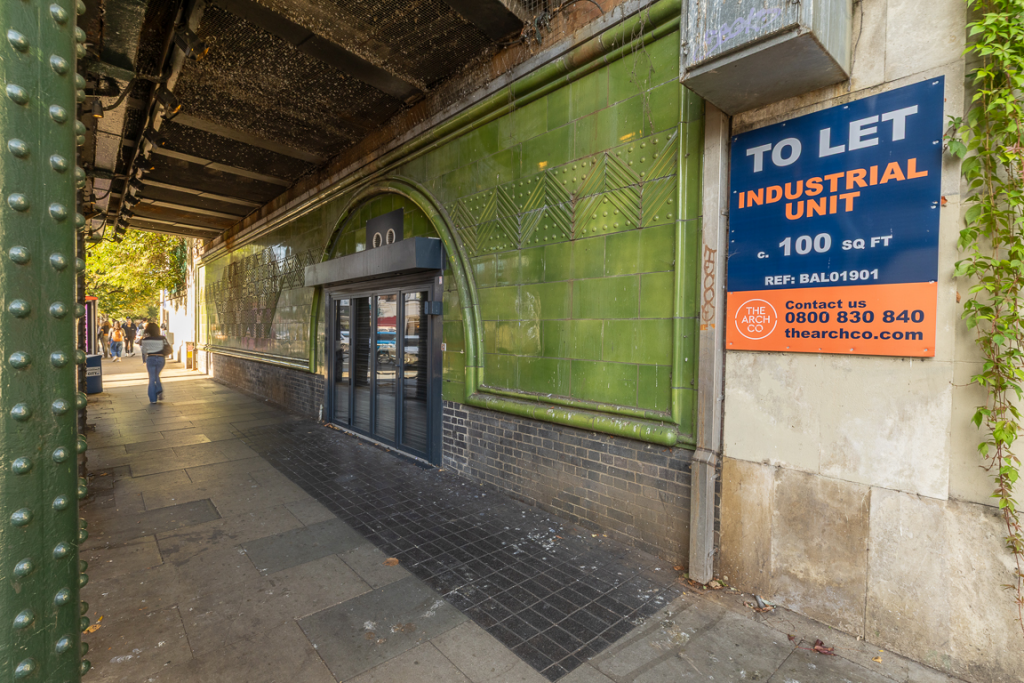 The front of an arch, with a fully glazed frontage and door allowing you to see into the arch interior.
