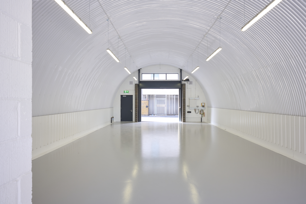 The front of an arch with an open electric roller shutter entrance big enough for vehicle access, and separate pedestrian door.