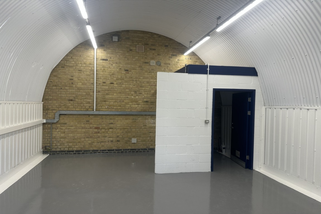 An empty arch with lining and a WC cubicle to the back