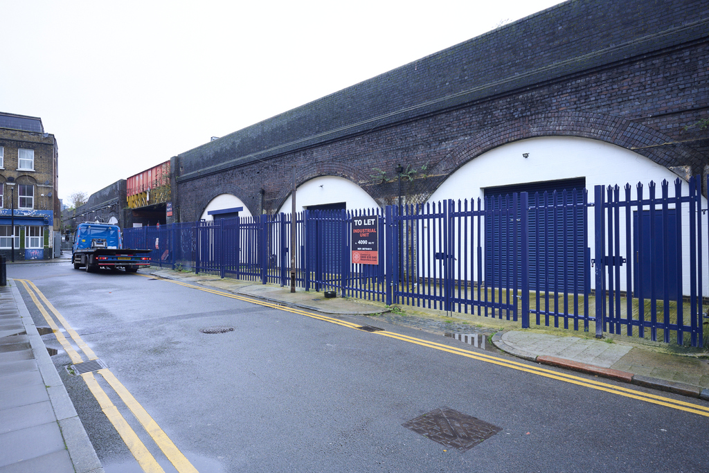 An estate, with multiple warehouse units next to each other. The arches have closed electric roller shutter entrances.
