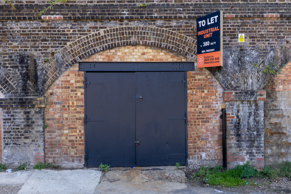 The front of an arch with a closed metal concertina door that can be pulled back fully.
