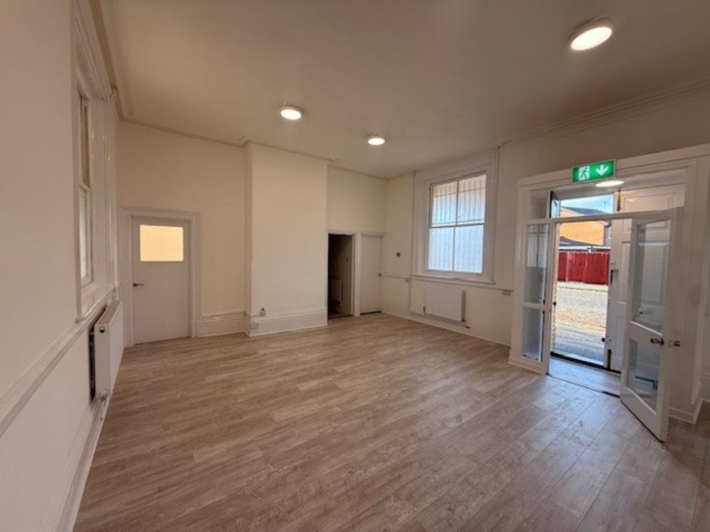 The front of an arch, with a fully glazed frontage and door allowing you to see into the arch interior.