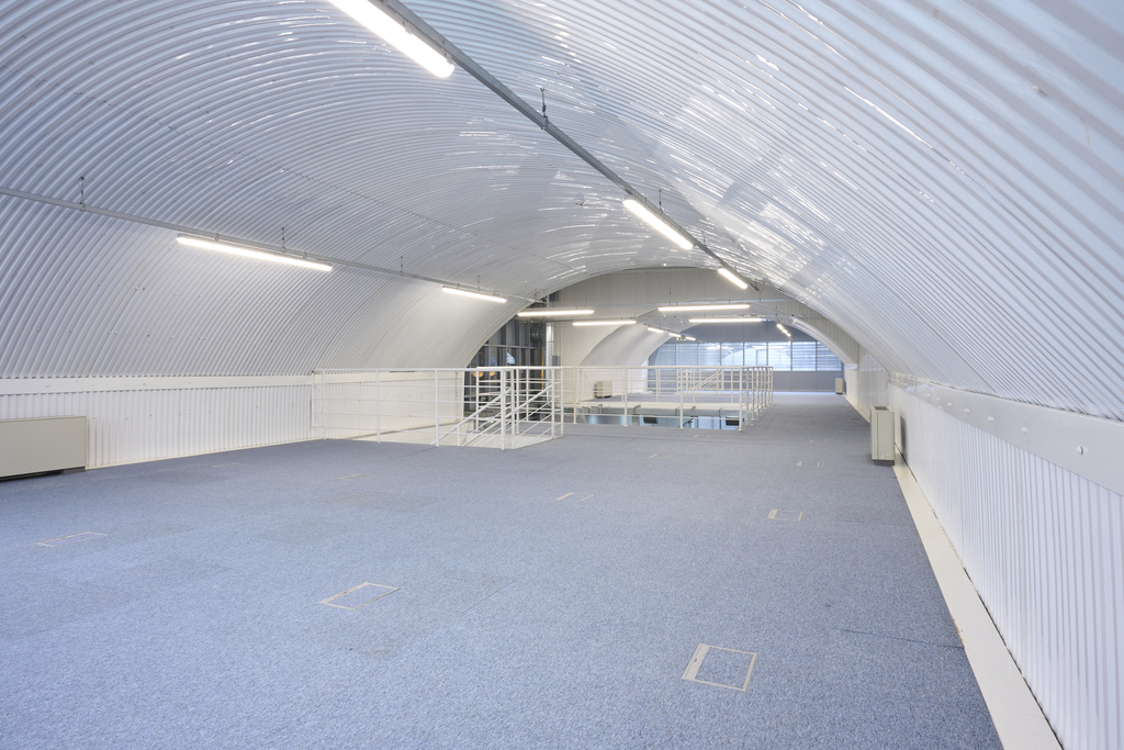 The mezzanine level of an arch, with carpet and lined white.