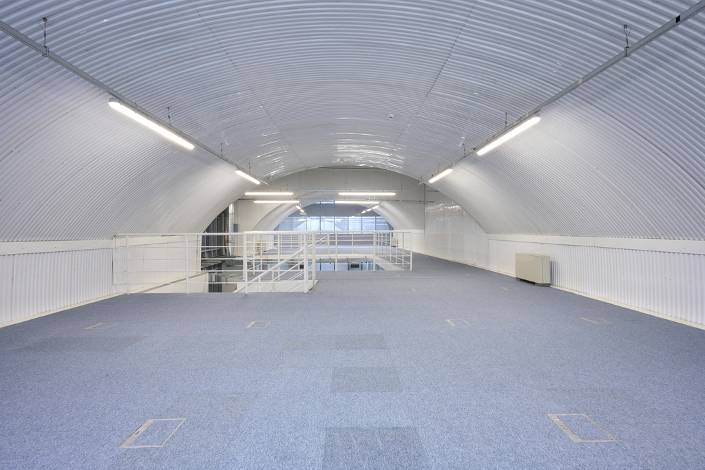 The mezzanine level of an arch, with carpet and lined white.