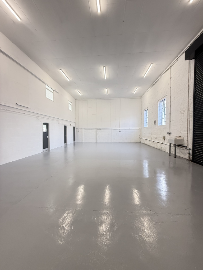 An empty arch with white lining and a WC cubicle to the back.