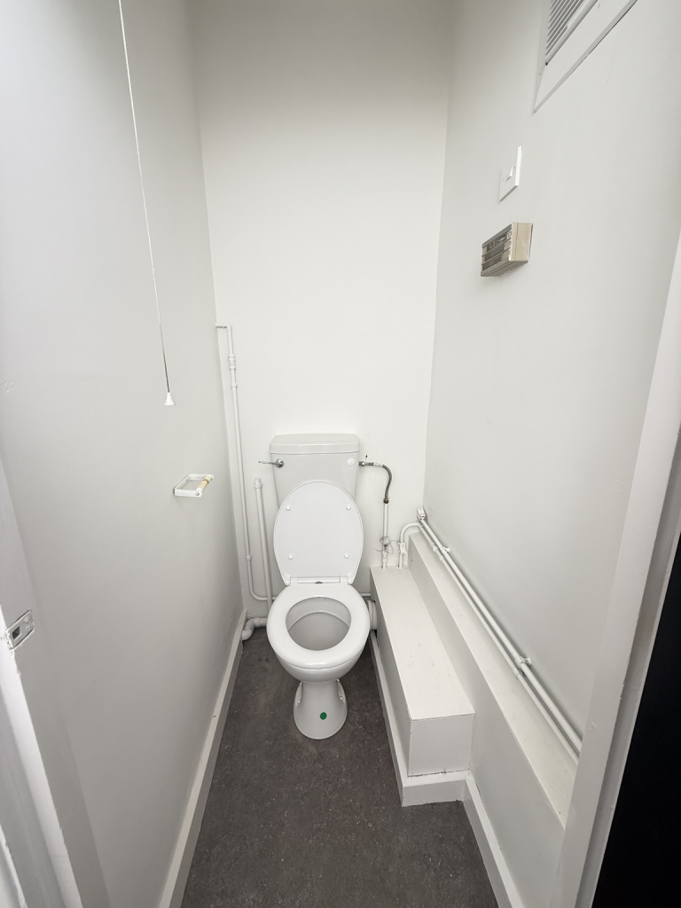 An empty arch with lining and a WC cubicle to the back