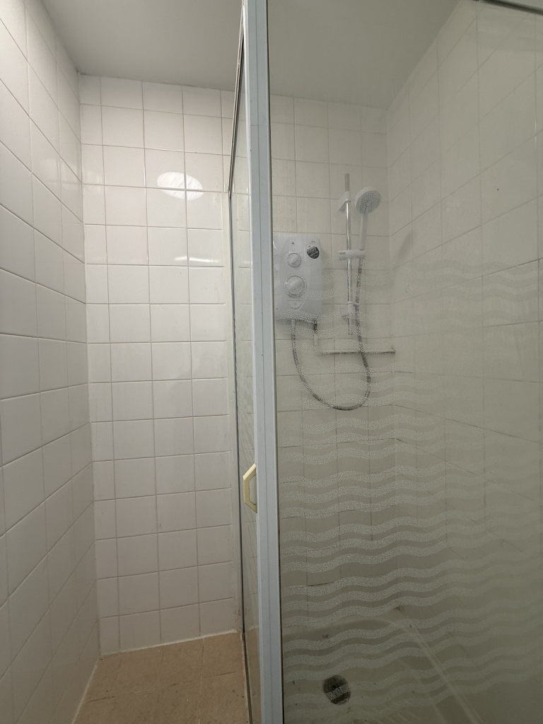 An empty arch with white lining and a WC cubicle to the back.