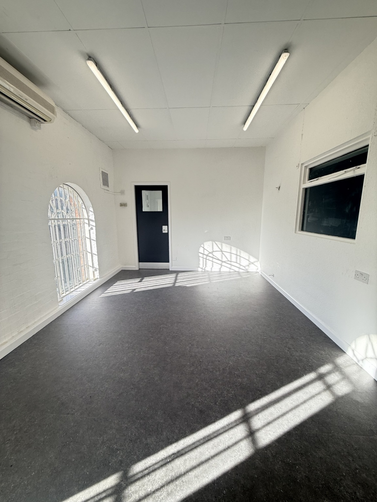 The ground floor of an empty arch, suitable to use as an office unit, with carpet and a WC.