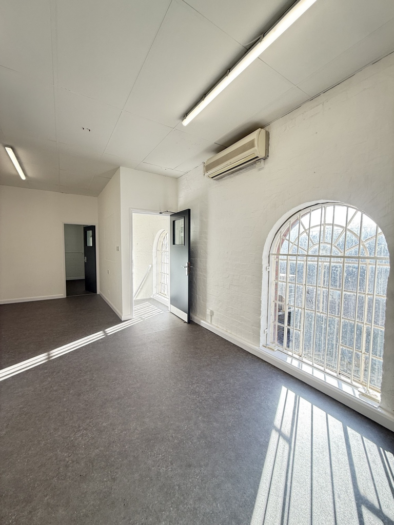 The ground floor of an empty arch, suitable to use as an office unit, with carpet and a WC.