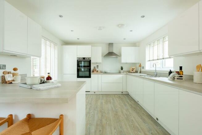Long kitchen with ample storage and worktop space plus breakfast bar