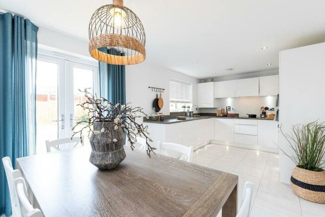 The open-plan kitchen/dining area features double doors out to the garden