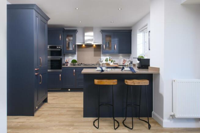 Open-plan kitchen/diner with glazed bay leading to garden in Bradgate style home