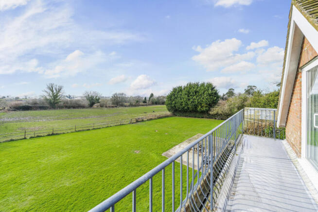 Views from Master Bedroom balcony over the private South facing rear garden, neighbouring field and South Downs beyond