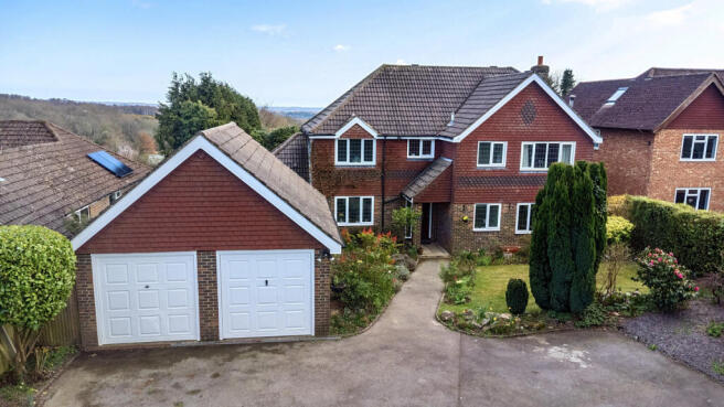 Front elevation, large detached double garage, and private parking for five to six vehicles