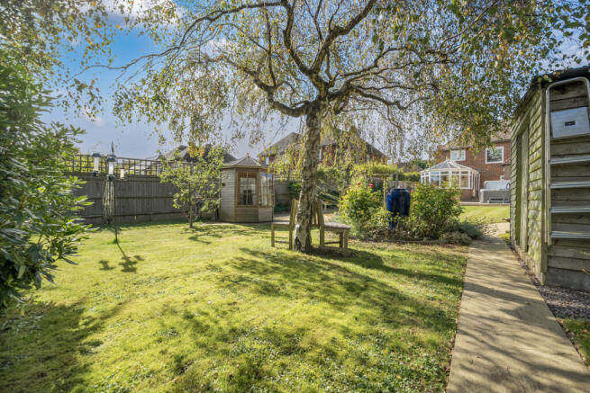 Family friendly rear garden with numerous multi functional outbuildings