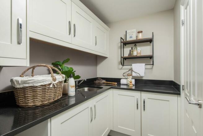 Holden utility room with white cabinets and black counters