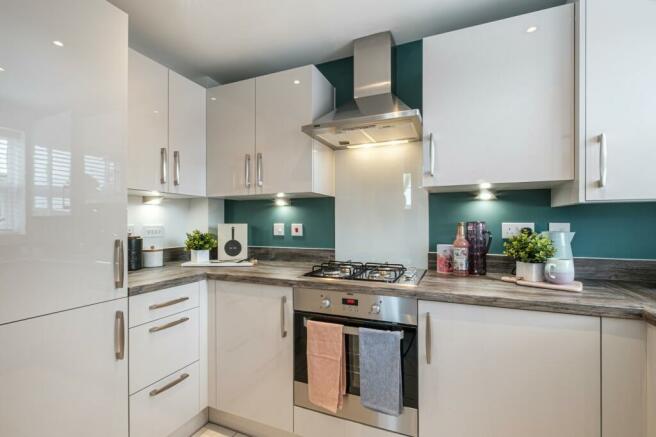 Kitchen with green feature walls and shiny white cupboards