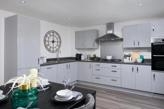 Open-plan kitchen/diner with integrated appliances and French doors leading onto garden in Ingleby s