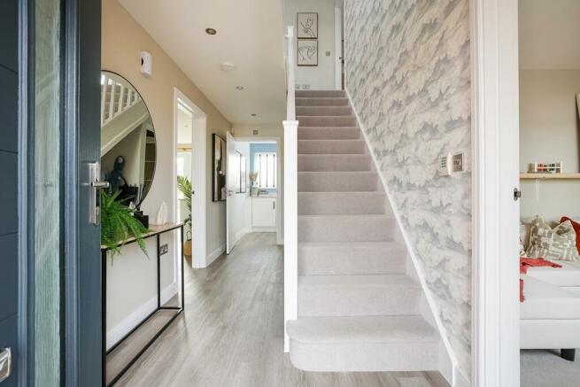 The central entrance hall is welcoming and has space for fitted understairs storage