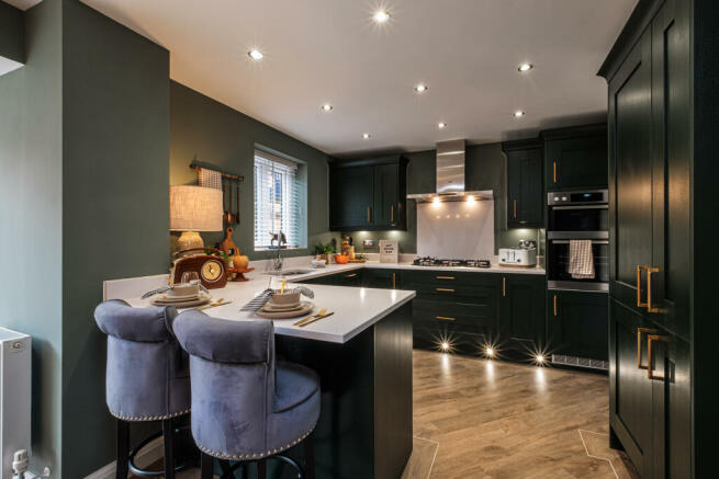 Kitchen with dark cupboards, wooden floor and a breakfast bar