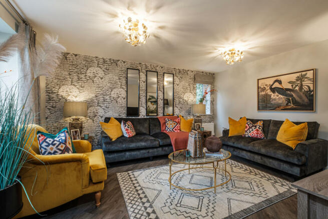 Vibrant lounge with grey and yellow sofas and patterned wallpaper