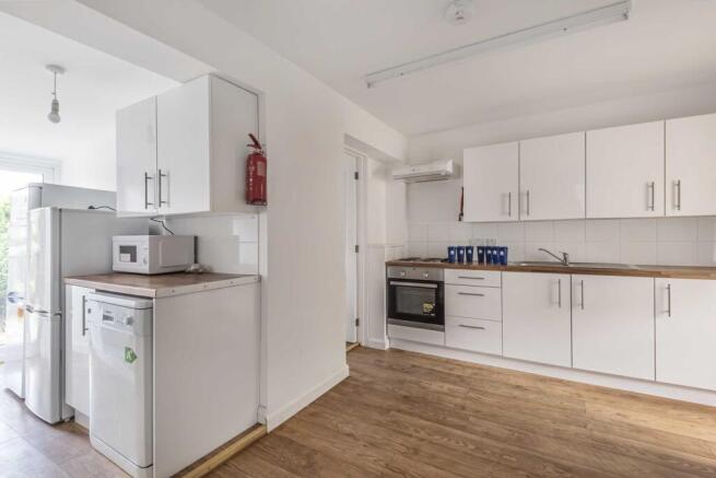 Bright, modern kitchen with white fitted cabine...
