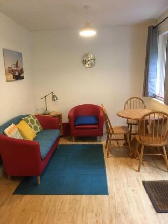 Bright, well-kept living room with colorful sea...