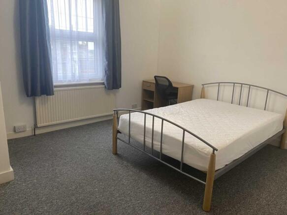 Bright, simply furnished double bedroom with a ...