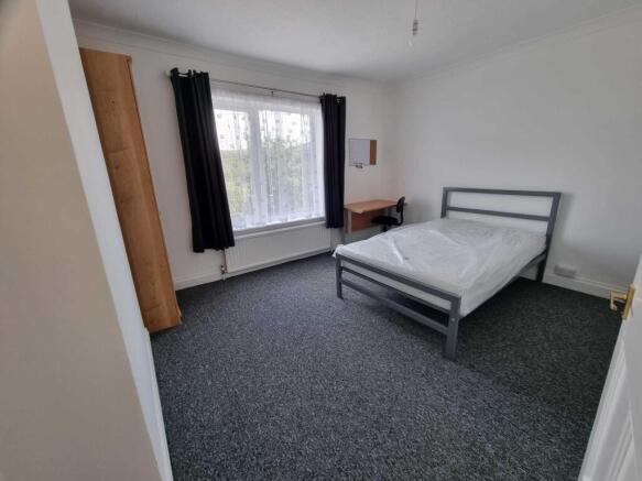 Bright, simply furnished double bedroom with a ...