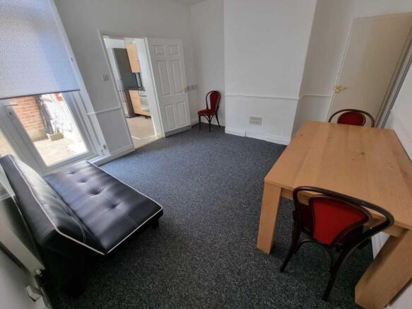 Bright, simply furnished living room with a lar...