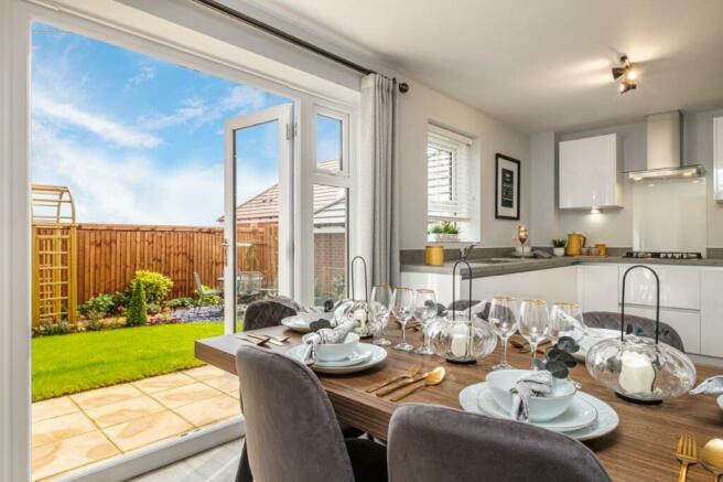 Photo of a kitchen diner with open French doors to a landscaped garden