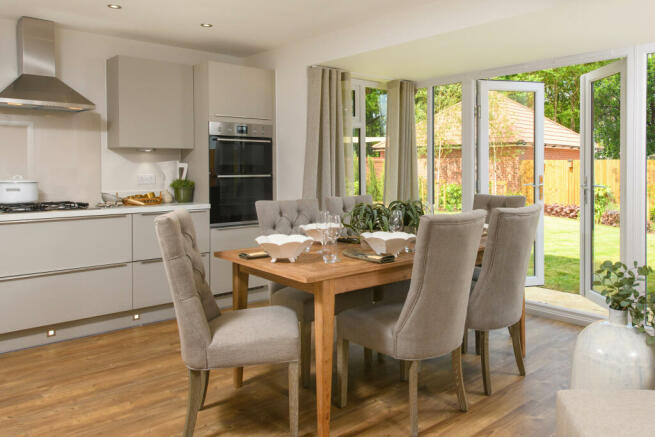 Open-plan kitchen with integrated appliances, dining area & family room with French doors leading on