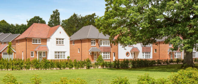 Modern residential houses with red and white brick exteriors, surrounded by greenery under a clear b