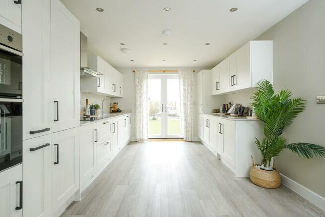 The kitchen is light and spacious with French doors leading to the garden