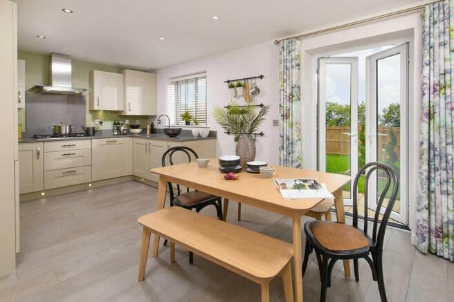 An open plan kitchen and dining area leads through double doors to the garden
