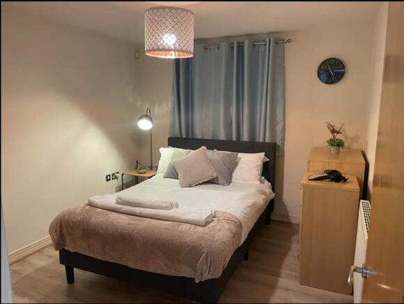 A cozy and well-lit double bedroom featuring mo...