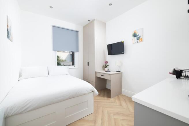 This inviting double bedroom features a cozy at...