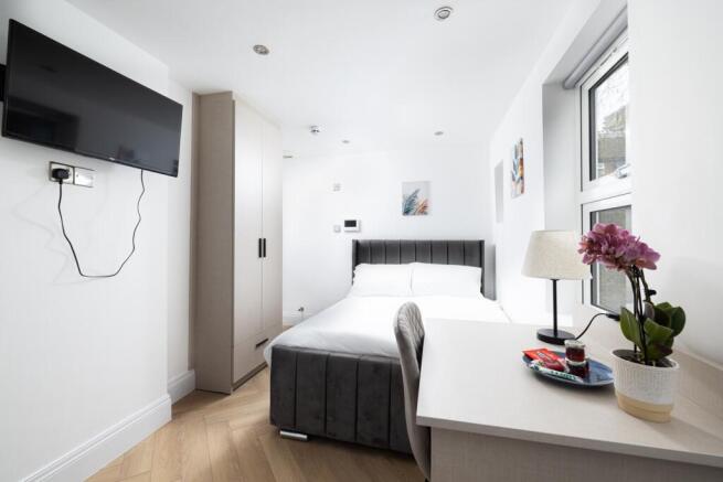 This inviting double bedroom features a comfort...