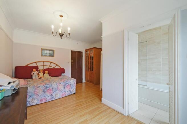 A spacious and bright master bedroom featuring ...