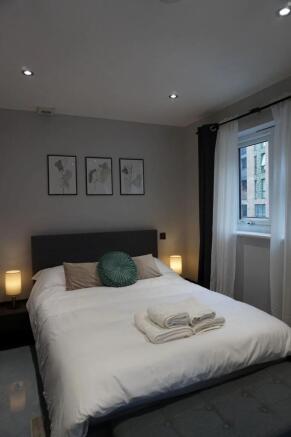 A stylish and cozy master bedroom featuring a n...