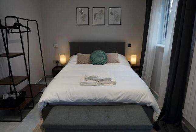 A cozy and well-kept double bedroom featuring a...