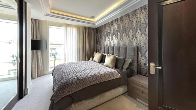 A stylish master bedroom featuring a plush doub...