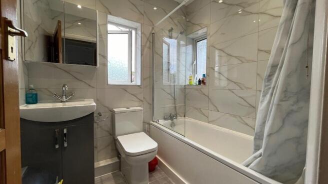 A bright and modern bathroom suite featuring a ...