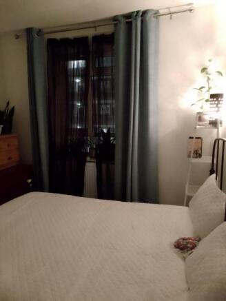Cozy double bedroom featuring a comfortable bed...