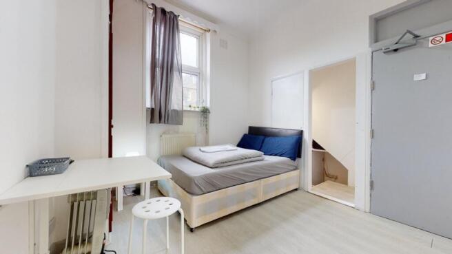 A bright and tidy single bedroom featuring a co...