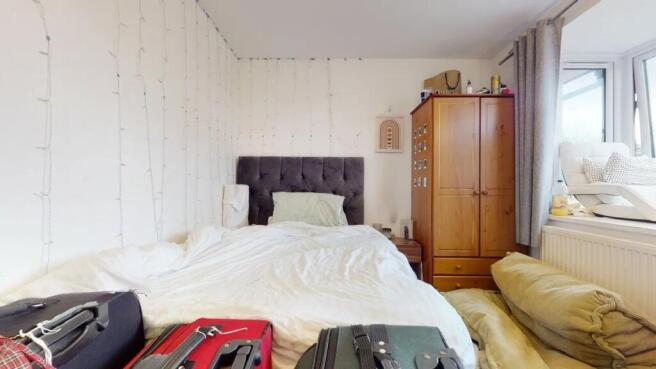 A cozy double bedroom featuring a plush grey he...