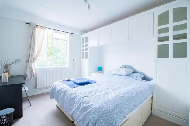 Bright and airy master bedroom featuring a comf...