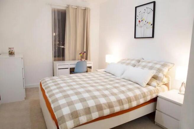 A bright and inviting master bedroom featuring ...